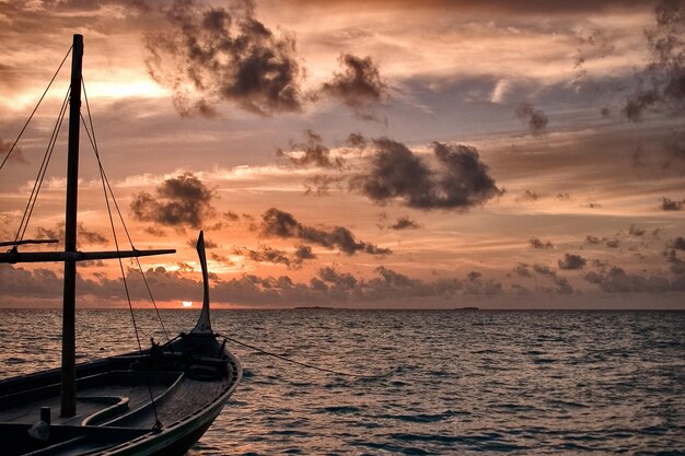 Foto boot verankerd in de zee tegen de hemel bij zonsondergang