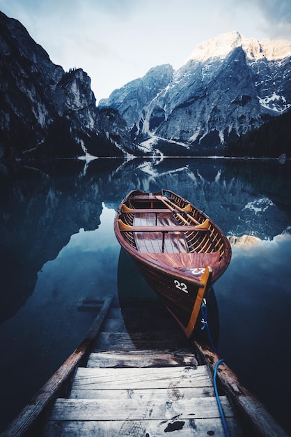 Foto boot verankerd op een rustig meer tegen een berg tijdens de winter