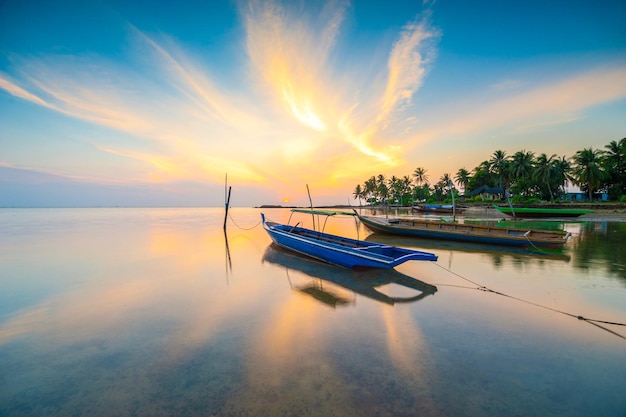 Boot verankerd op zee tegen de hemel bij zonsondergang