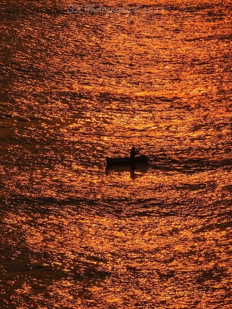 Foto boot zeilt op zee bij zonsondergang