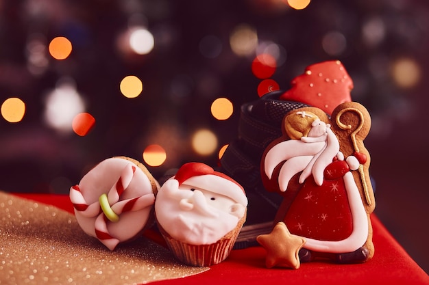 Boots filled of treats Saint Nicholas cookies and cupcakes on bokeh background Traditional holiday in Europe Copy space