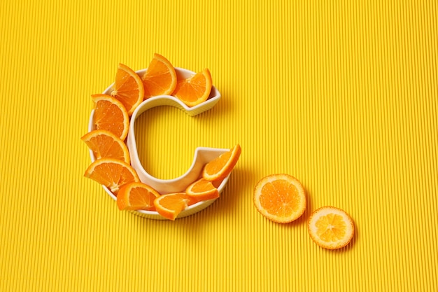 Bord in vorm van letter C met stukjes sinaasappel