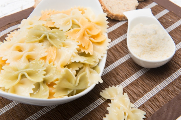 bord Italiaanse farfalle pasta met geraspte kaas geserveerd op tafel