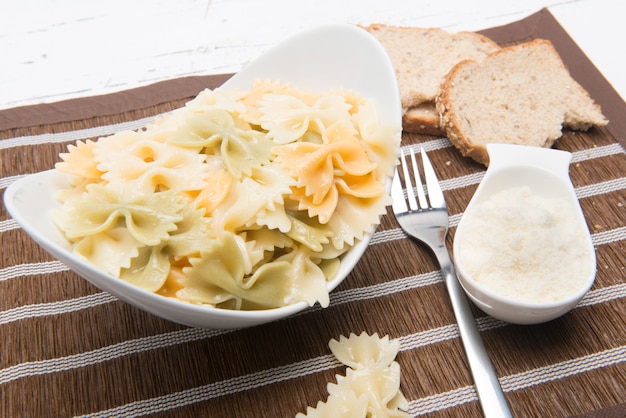 bord Italiaanse farfalle pasta met geraspte kaas geserveerd op tafel