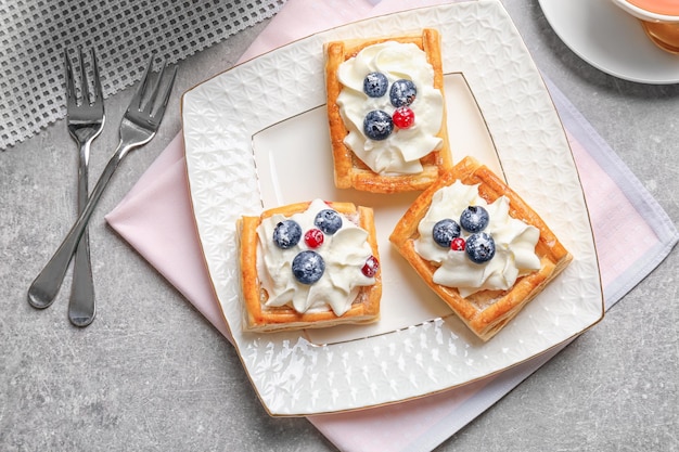 Bord met gebak en vorken op grijze tafel