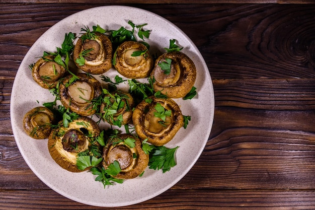 Bord met gebakken champignons, dille en peterselie op een houten tafel Bovenaanzicht