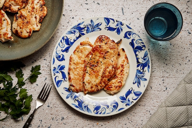 Bord met gekookte gemarineerde kippenborstfilets op een granieten tafel