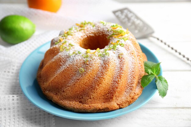 Bord met heerlijke citruscake en sinaasappelschil op lichttafel