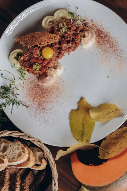 Bord met heerlijke tartaar, geroosterd brood en salade op een houten tafel.