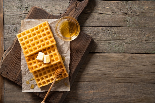 Bord met heerlijke wafelhoning en een boterham. Op een houten ondergrond. Uitzicht van boven