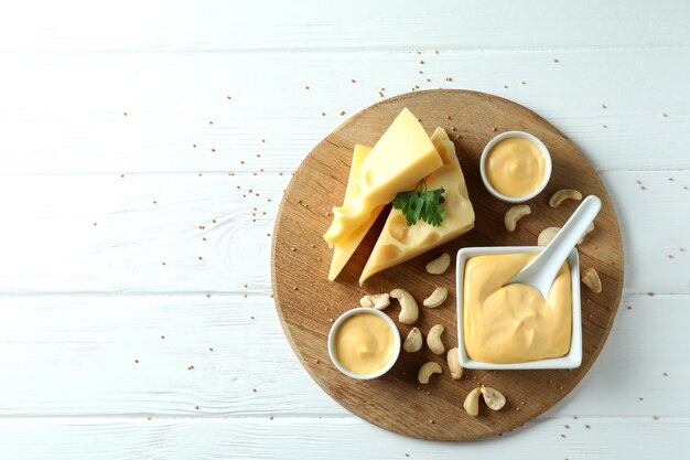 Bord met kaassaus en ingrediënten op witte houten tafel