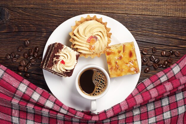 Bord met lekker gebak en koffiekopje op oude houten tafel. Bovenaanzicht