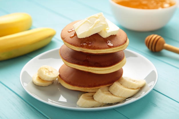 Bord met lekkere bananenpannenkoekjes op blauwe achtergrond