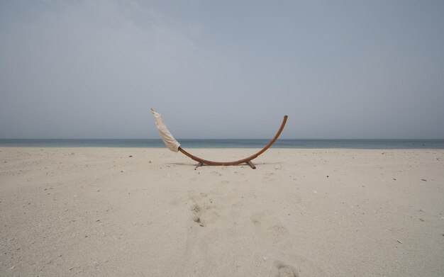 bord met oceaanachtergrondhangmat die op het strand slingert