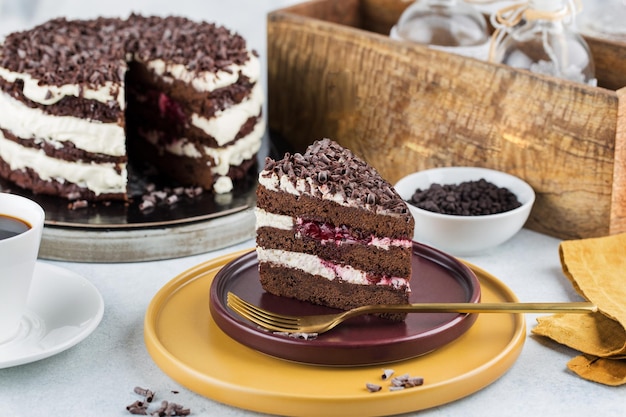 Bord met plakje lekkere zelfgemaakte chocolade en kersencake op tafel