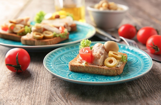 Bord met smakelijke kipbruschetta op houten tafel