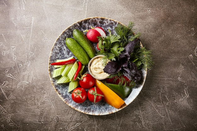 Bord met tomaten zoete paprika radijs en selderij peterselie dille koriander groene ui rode basilicum