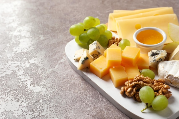 Bord met verschillende soorten heerlijke kaas en snacks op marmeren achtergrond