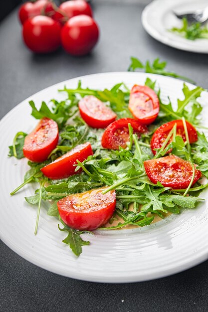 bord salade tomaat rucola geraspte kaas olijfolie gezonde maaltijd voedsel snack op tafel