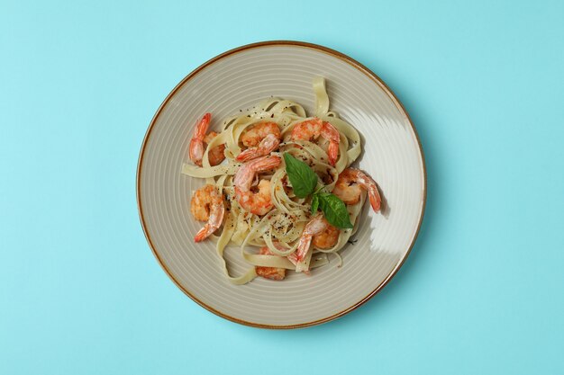 Bord smakelijke garnalenpasta op blauw