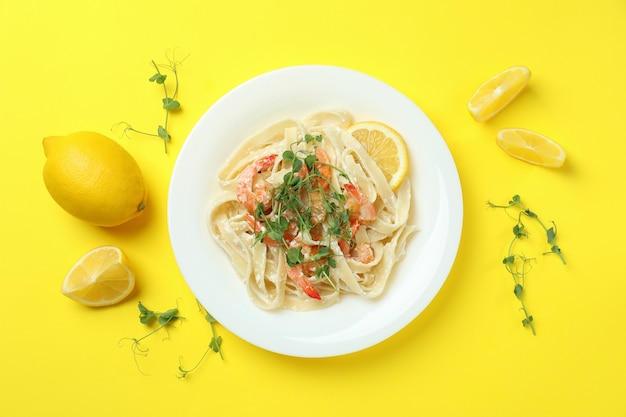 Bord smakelijke garnalenpasta op geel