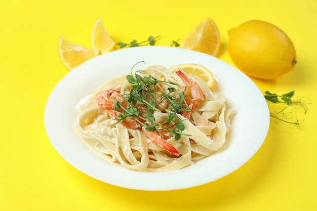 Bord smakelijke garnalenpasta op geel