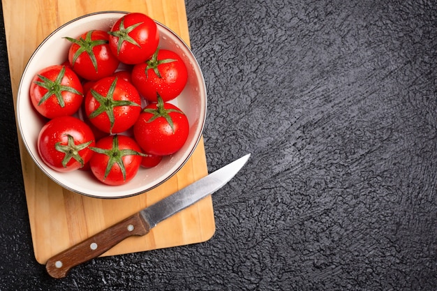 Bord vol tomaten op de zwarte tafel