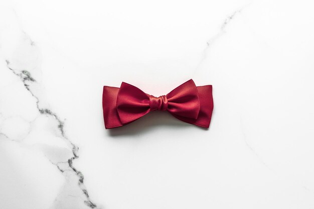 Bordeaux silk ribbon on marble background flatlay