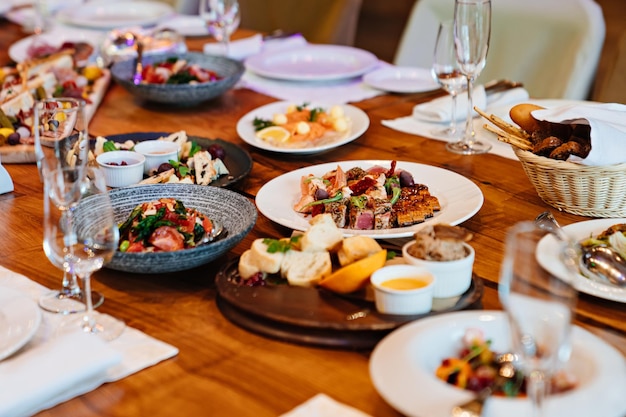 Borden met hapjes op tafel geserveerd voor de vakantie in de restaurantcatering en levering van kant-en-klare delicatessen voor thuis voor het feest