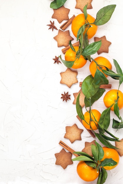 Border of Christmas star cookies with spices and mandarin on white background with copyspace. Top view