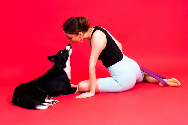 Собака-бордер-колли и спортивная фитнес-женщина перед желтым красным фоном