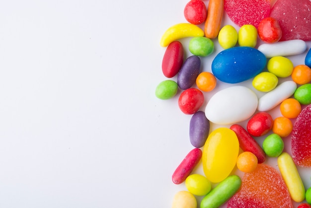 Border of colorful jelly candies on white