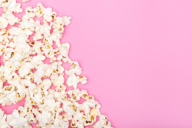 Photo border frame of popcorn on pink background top view copy space