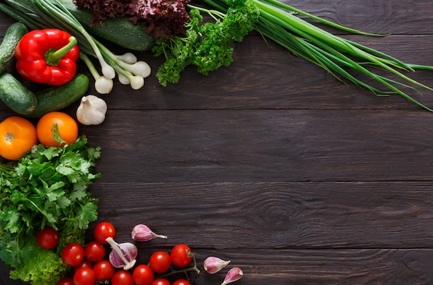 Border of fresh vegetables on wooden background with copy space