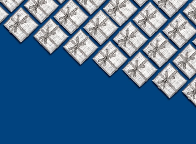 青い背景のクリスマスの装飾に銀の光沢のあるギフトの境界線
