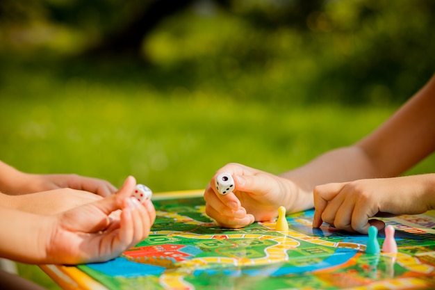 Bordspel en kinderen vrije tijd concept. kinderen spelen. mensen met figuren in de hand. chips bij kinderen spelen. concept van bordspellen. dobbelstenen, chips en kaarten. feest spelletjes