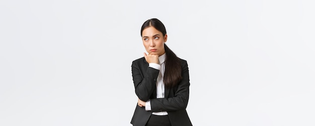 Bored and annoyed female entrepreneur looking unamused away while sitting boring meeting attend uninteresting office gathering standing white background dying boredom