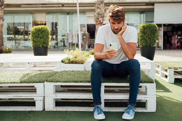 Bored bearded man checking his phone