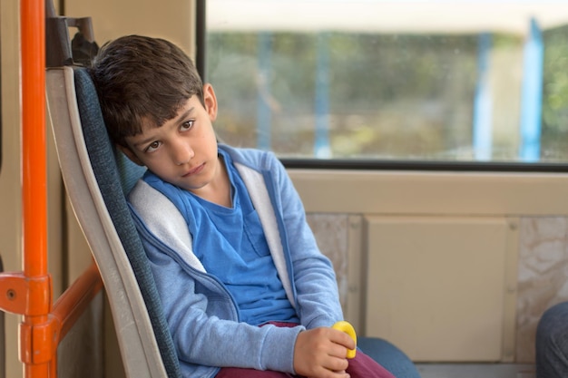 Foto ragazzo annoiato seduto nel tram