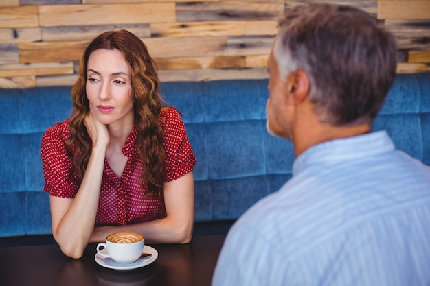  bored couple having coffee together 