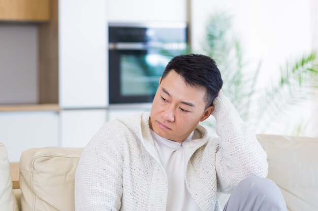 bored friends young asian man sitting on sofa at home alone