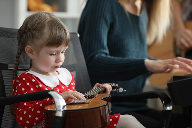 Bored girl hold guitar and fooling around with musical instrument