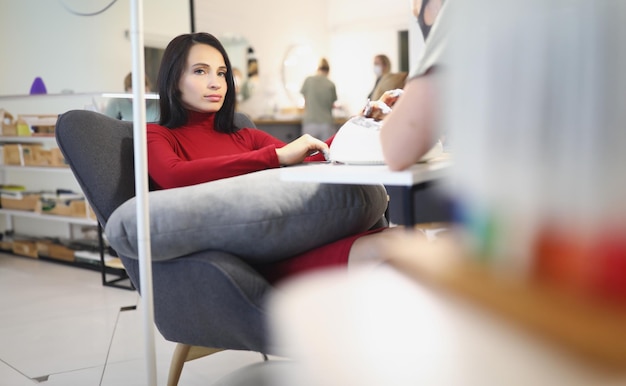 Bored lady client on manicure and pedicure appointment in beauty salon