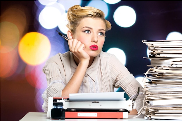 A bored office worker sitting behind a large stack of paperwork