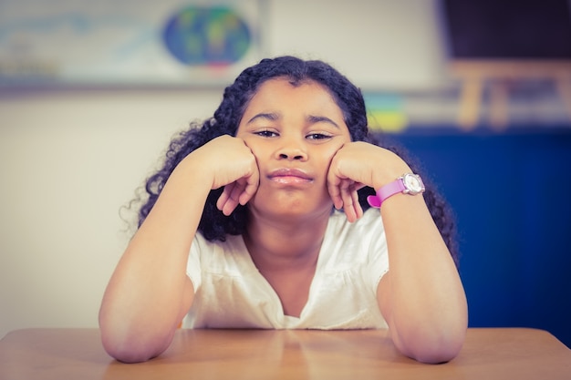 Photo bored pupil sitting in a classroom