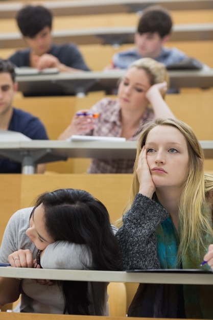 Bored studenten zitten in een collegezaal