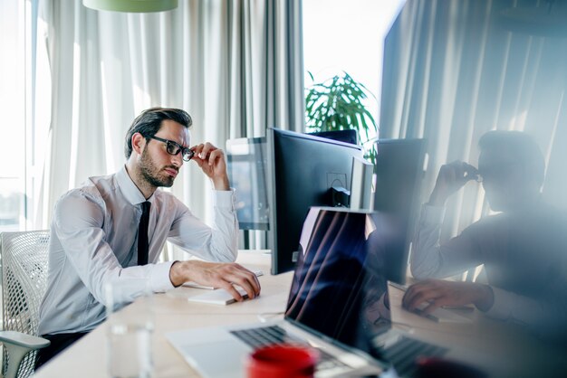 Uomo d'affari stanco annoiato che finisce il suo lavoro al suo posto di lavoro. concetto di ufficio.