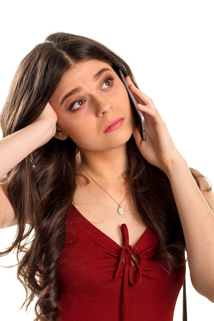 Bored woman holds cell phone. Small pendant on girl's neck. Your offer doesn't interest me. It's a waste of time.