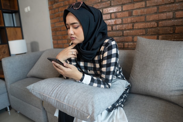 Bored woman at home using her mobile phone