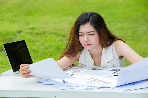 テーブルに座っている退屈な女性。デスクで寝る過労で疲れた若い女性。